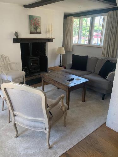 a living room with a couch and a table at Lovely Two Bedroom Town House - Minimum 2 Night Stay in Midhurst