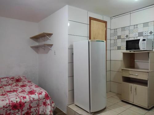 a kitchen with a refrigerator and a microwave at Pousada Brum in Pelotas