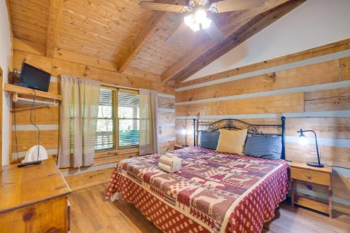 a bedroom with a bed and a wooden wall at Gatlinburg Cabin with Hot Tub about 6 Mi to Downtown! in Gatlinburg