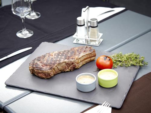 a steak on a cutting board on a table at Campanile Versailles Buc in Buc
