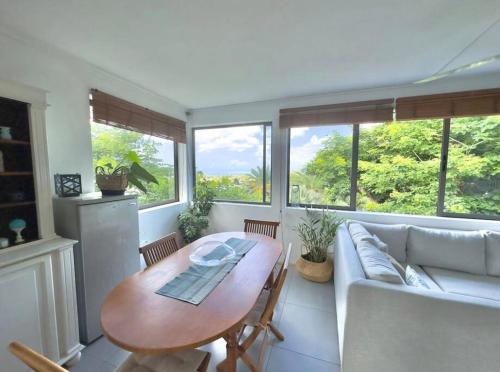 a living room with a table and a couch at Seaview Sunset Apartment in Tamarin