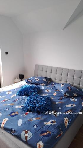 a bed with a blue comforter with animals on it at Sunset Beach in Sarbinowo