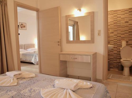 ein Badezimmer mit Waschbecken, Toilette und Spiegel in der Unterkunft Nikos Hotel in Matala