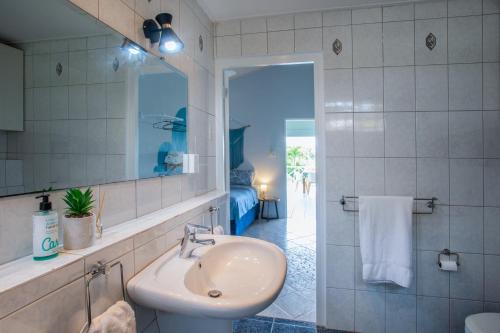 a bathroom with a sink and a mirror at Casa Monte Bello in Willemstad