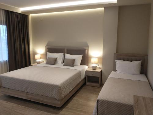 une chambre d'hôtel avec 2 lits et 2 lampes dans l'établissement Menta, à Litochoro