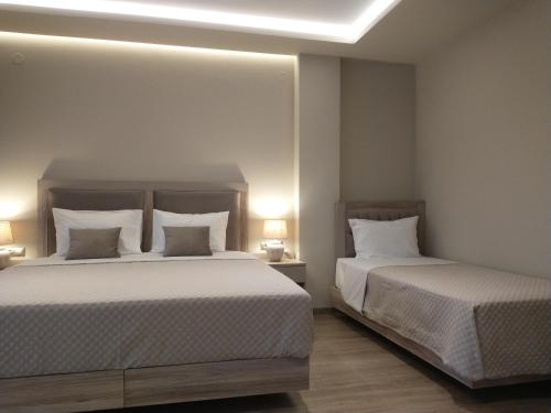 a bedroom with two beds and two lamps at Menta in Litochoro