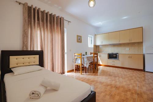 een slaapkamer met een bed en een tafel en een keuken bij Apartments & Hotel Eleanna in Sarandë