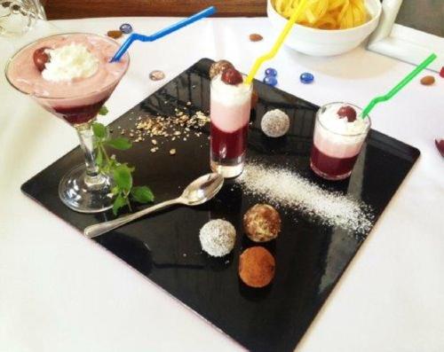 a black plate with three desserts on a table at Hillside Apartman in Dunaszentmiklós