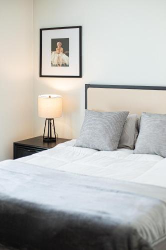 a bedroom with a white bed and a lamp at Luxury Apartment With The Hollywood Hills View in Los Angeles