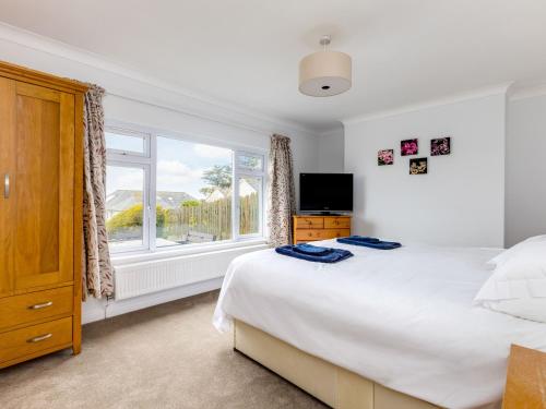 a bedroom with a bed and a large window at Chy-An-Var in Polzeath
