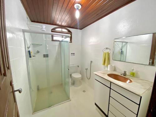 Casa Cantinho de Arembepe - Linda casa com piscina no litoral norte da Bahia في كامساري: حمام مع دش ومغسلة ومرحاض