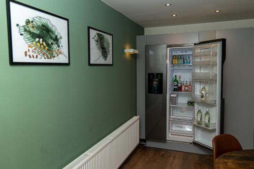 a kitchen with an open refrigerator in a room at Luxe Vakantiehuis Zeeland in Wilhelminadorp