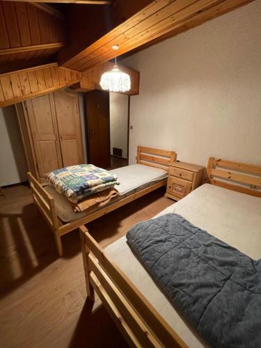um quarto com 2 camas e um lustre em Appartamento Lost em Ceresè