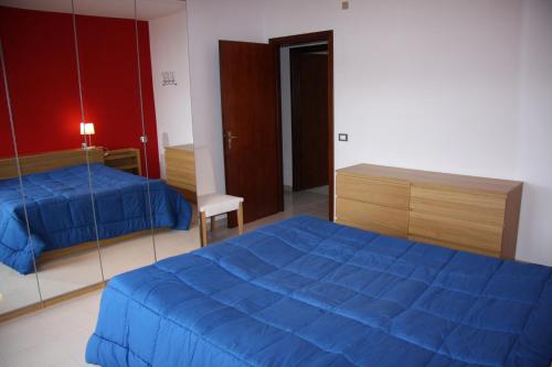 トラーパニにあるAppartamento Giglioのベッドルーム(青いベッド1台、鏡付)
