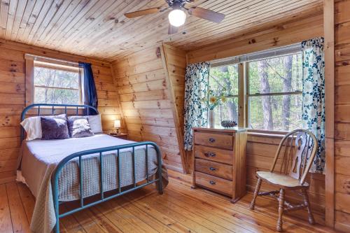 1 dormitorio en una cabaña de madera con 1 cama y 1 silla en Home Near Hoosier National Forest with Fire Pit!, en Taswell