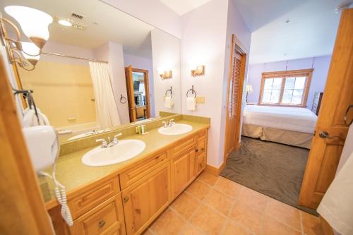 a bathroom with two sinks and a bed at Expedition Station 8597 in Keystone