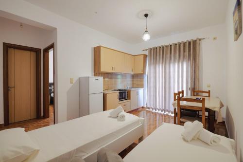 a kitchen with two white beds in a room at Hotel Eleana & Apartments in Sarandë