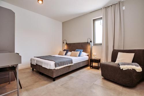 a bedroom with a bed and a couch at SOL luxury residence near the beach with shared heated pool in Božava