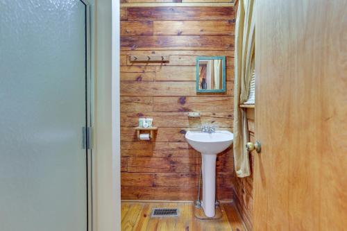 ein Badezimmer mit einem Waschbecken und einer Holzwand in der Unterkunft Comfy Taswell Cabin Rental - Community Amenities! in Taswell
