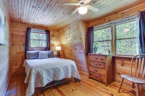 ein Schlafzimmer mit einem Bett in einer Holzhütte in der Unterkunft Comfy Taswell Cabin Rental - Community Amenities! in Taswell