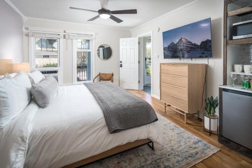 a bedroom with a large white bed and a dresser at The Victorian Inn Blowing Rock in Blowing Rock
