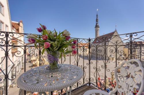 a vase of flowers sitting on a table on a balcony at Historic Residence Apartments at Old Town in Tallinn
