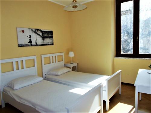 Duas camas num quarto com paredes amarelas em Angelica em Pisciotta