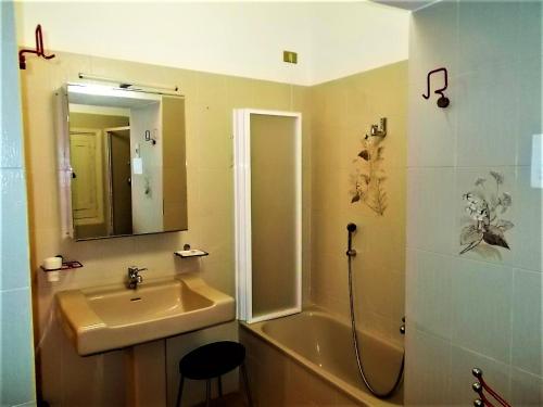 uma casa de banho com um lavatório e um chuveiro com um espelho. em Angelica em Pisciotta