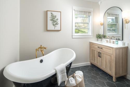 a bathroom with a white tub and a sink at The Victorian Inn Blowing Rock in Blowing Rock