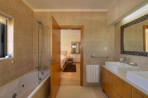 a bathroom with a tub and a sink and a shower at Vila Vida in Ferragudo