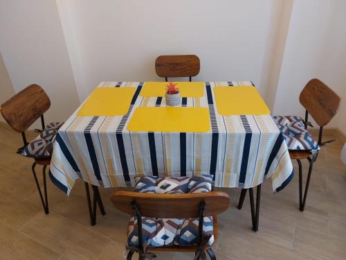a dining room table with chairs and a striped table cloth at Departamento confortable en Quito in Quito