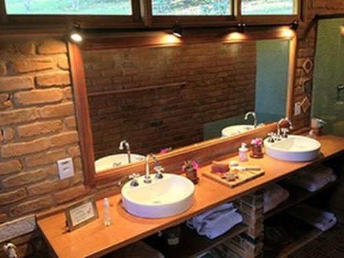 uma casa de banho com 2 lavatórios e um espelho grande em Quinta da Prata em Bocaina de Minas