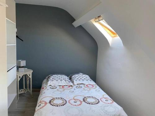 1 dormitorio con cama con almohada y ventana en Maison proche de la mer 110m2, en Glatigny