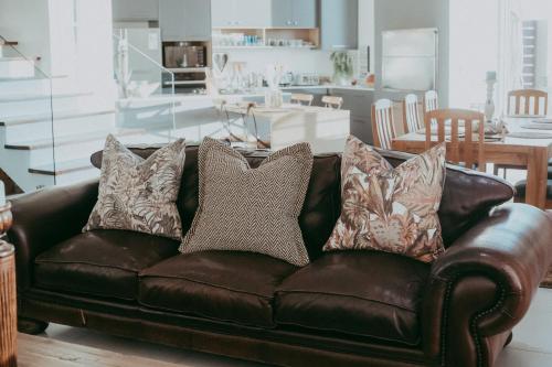 a brown leather couch with pillows in a living room at Oceana View in Swakopmund