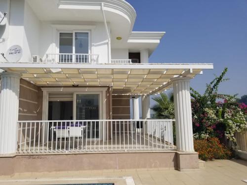 a white house with a balcony with a railing at Villa Rana The Royal Links Sarigerme in Ortaca