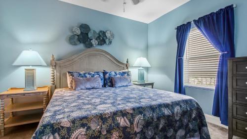 Dormitorio azul con cama y ventana en Sunsational at Laketown Wharf #1924 by Nautical Properties, en Panama City Beach