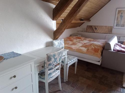 a bedroom with a bed and a desk and a chair at Le relais Poyo in Arquian