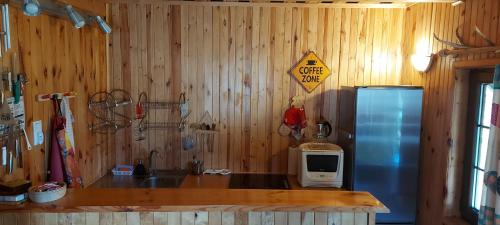 a kitchen with a counter with a microwave and a refrigerator at Gowidlino - Domek Letniskowy nad Jeziorem in Gowidlino