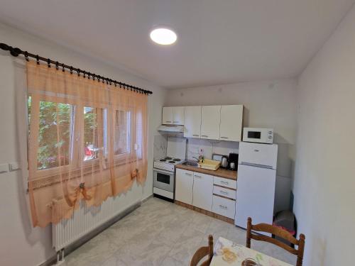 una pequeña cocina con fregadero y ventana en Apartments NONO, en Senj