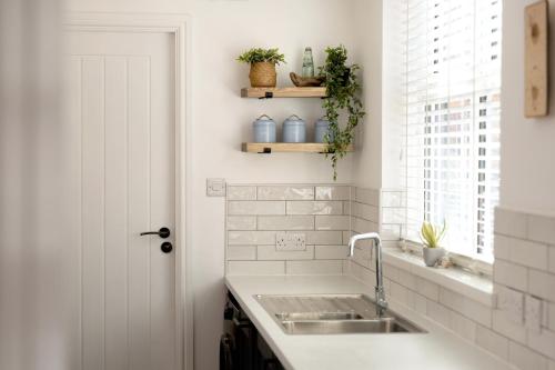 a white kitchen with a sink and a window at Low Tide @ Filey. Close to Beach. Dog Friendly. in Filey