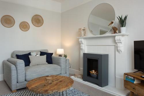 a living room with a couch and a mirror at Low Tide @ Filey. Close to Beach. Dog Friendly. in Filey