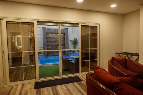 a living room with sliding glass doors with a view of a pool at M Residence New Cairo - Families only in Cairo
