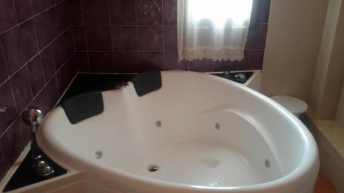a bath tub in a bathroom with purple tiles at Hotel Rural Los Abriles in El Toro