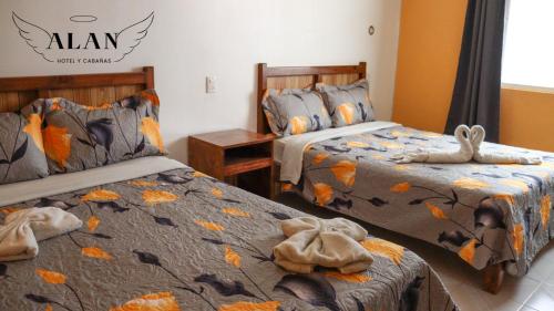 1 dormitorio con 2 camas y toallas. en Hotel y Cabañas Alan en Chignahuapan