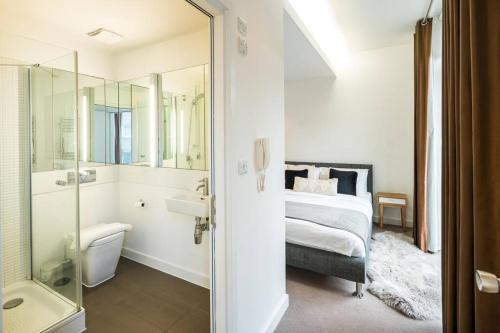ein Schlafzimmer mit einem Bett und ein Badezimmer mit einer Dusche in der Unterkunft Superb Retreat Flat Central in London
