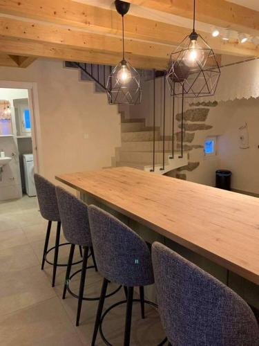 a kitchen with a wooden bar with chairs and stairs at Holiday home Ana in Cres