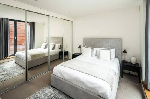 1 Schlafzimmer mit 2 Betten und einem großen Fenster in der Unterkunft Superb Retreat Flat Central in London