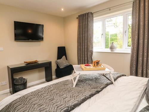um quarto com uma cama e uma televisão na parede em Kilmory Lodge em Poulton le Fylde