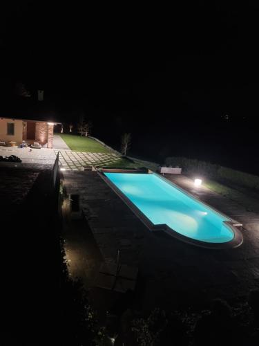 a large blue swimming pool at night at Ca' del magu in San Michele Mondovì