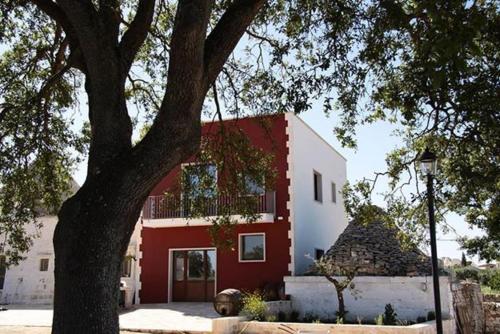 a red and white building with a tree in front of it at Masseria Catucci Agriturismo in Alberobello